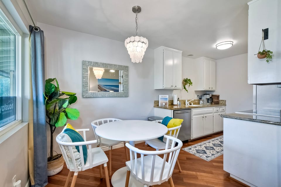 This dining table seats four and is located next to an attached galley kitchen.