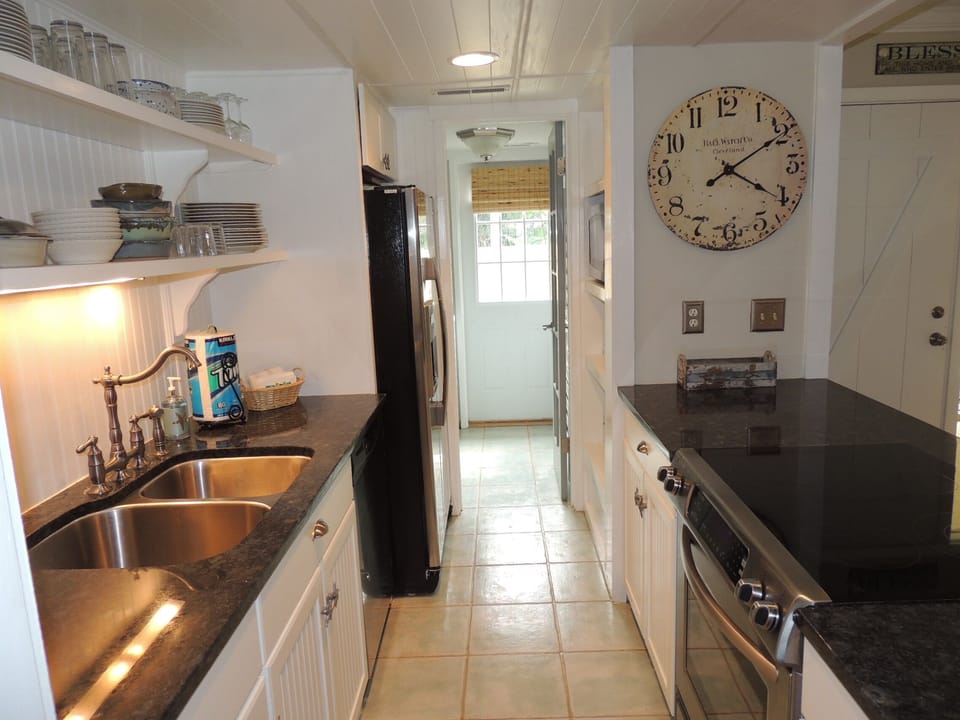 Kitchen looking into laundry with entrance to front fenced-in patio
