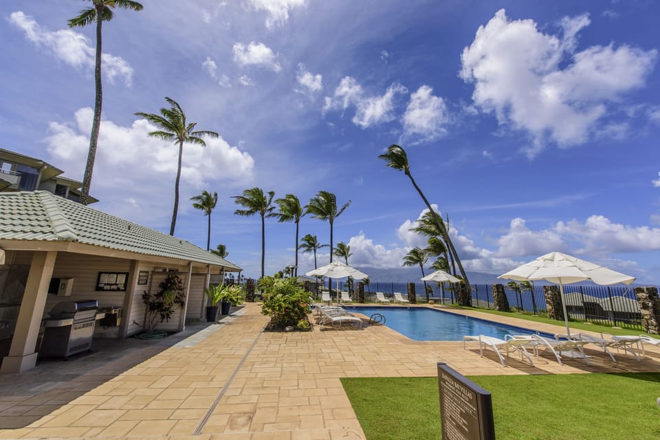 Pool deck has lounge chairs and umbrellas