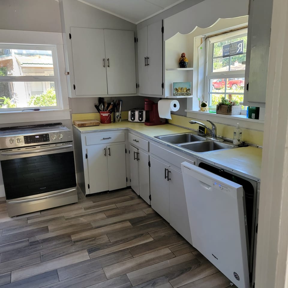 Kitchen with stainless steel refrigerator and stove.   Full stocked.