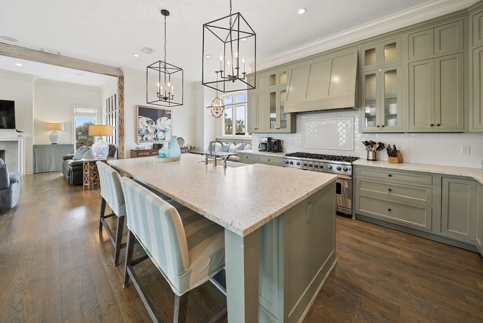 Your gourmet kitchen awaits with elegant sage cabinetry, marble countertops, and professional-grade appliances perfect for creating memorable meals together.
