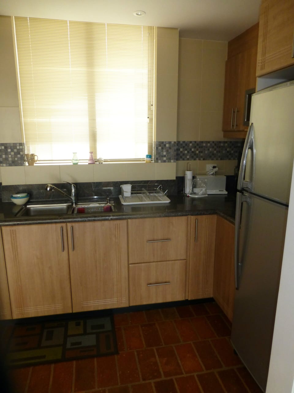 Kitchen - right side, full sized fridge and stainless steel sink