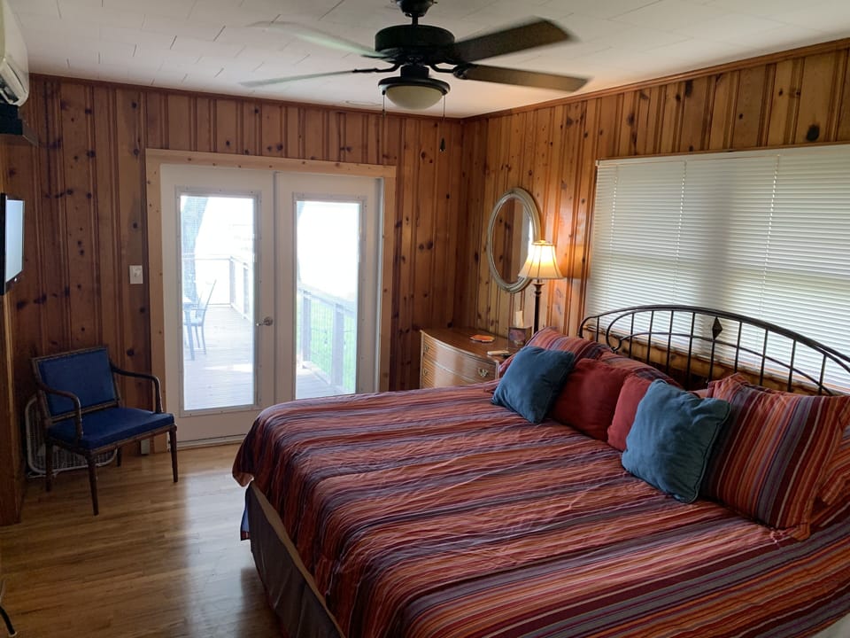 Master bedroom w/ king bed and entrance to back deck.
