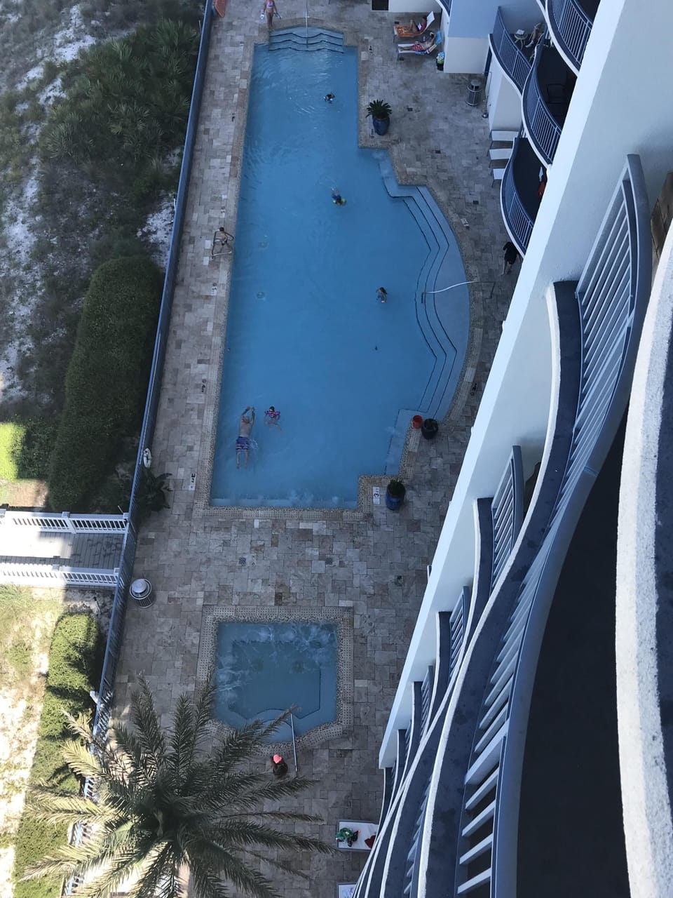 View of pool deck and hottub from balcony.
