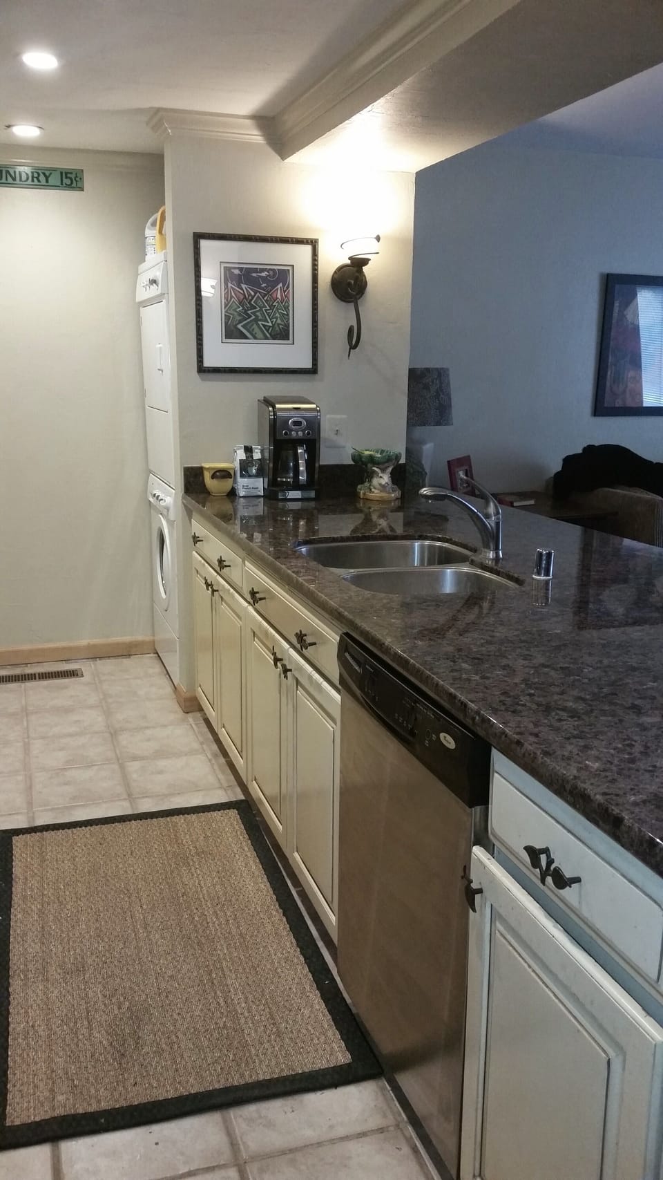 Galley Kitchen showing stacked washer and dryer at the far end of the kitchen.