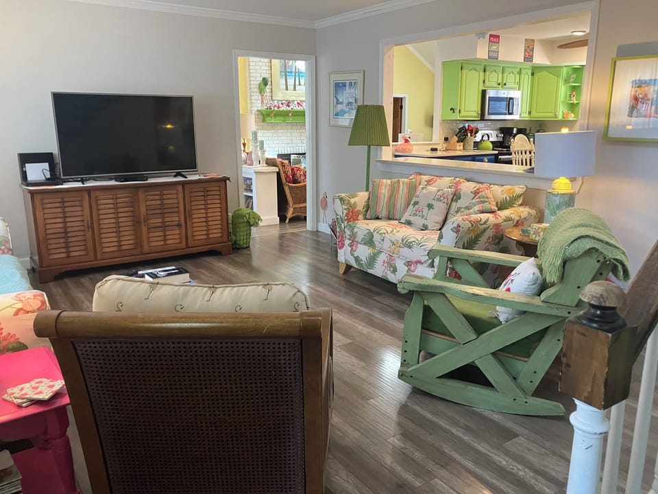 Living room with large smart TV. Open to kitchen and main living room.