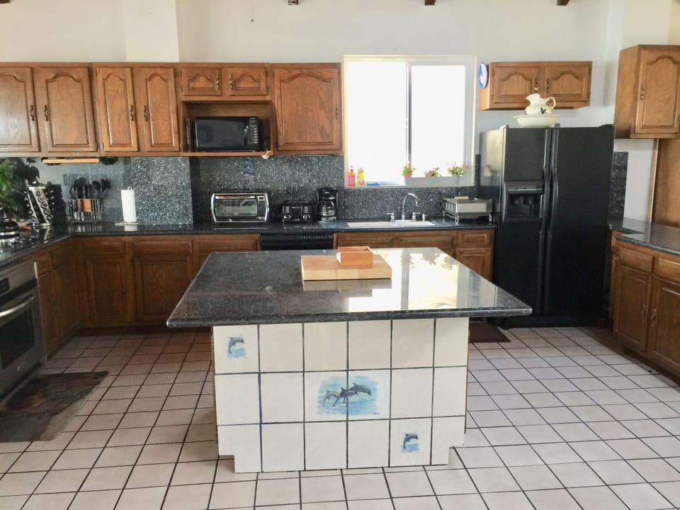 Open kitchen with vaulted ceilings and 80 feet of black granite countertops. 