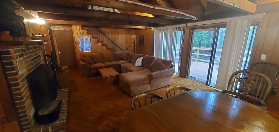 Open concept living room, high ceilings, flat screen TV, fireplace. 