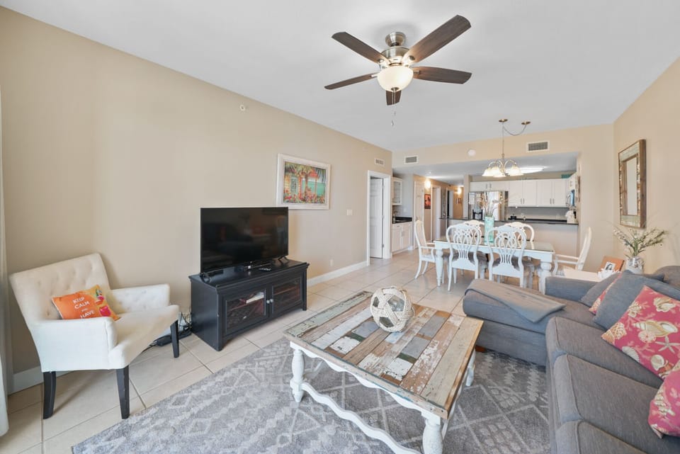 Relax in your spacious open-concept living space with comfortable seating, modern amenities, and a breezy ceiling fan overhead.