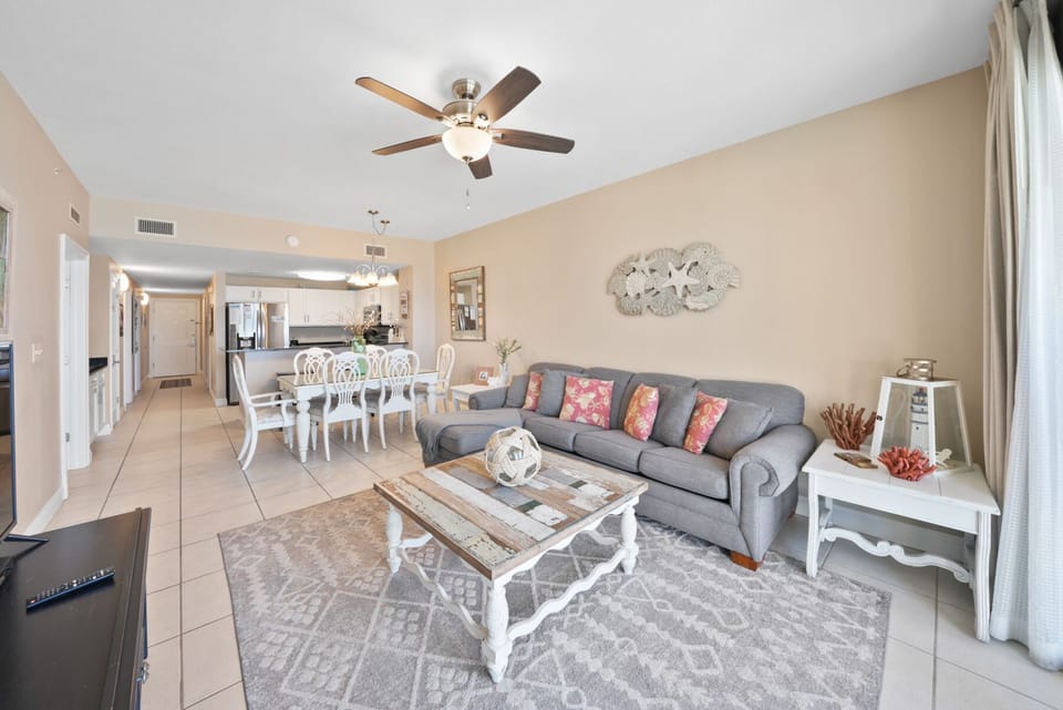 Unwind in your spacious living area with plush seating, coastal decor, and an open layout perfect for relaxation.