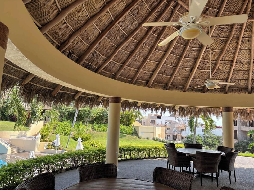 Beautiful palapa area featuring comfortable seating, perfect for relaxing outdoors. This shaded space offers a refreshing breeze and a cozy atmosphere, ideal for enjoying gatherings, reading, or simply unwinding while taking in the surrounding views.