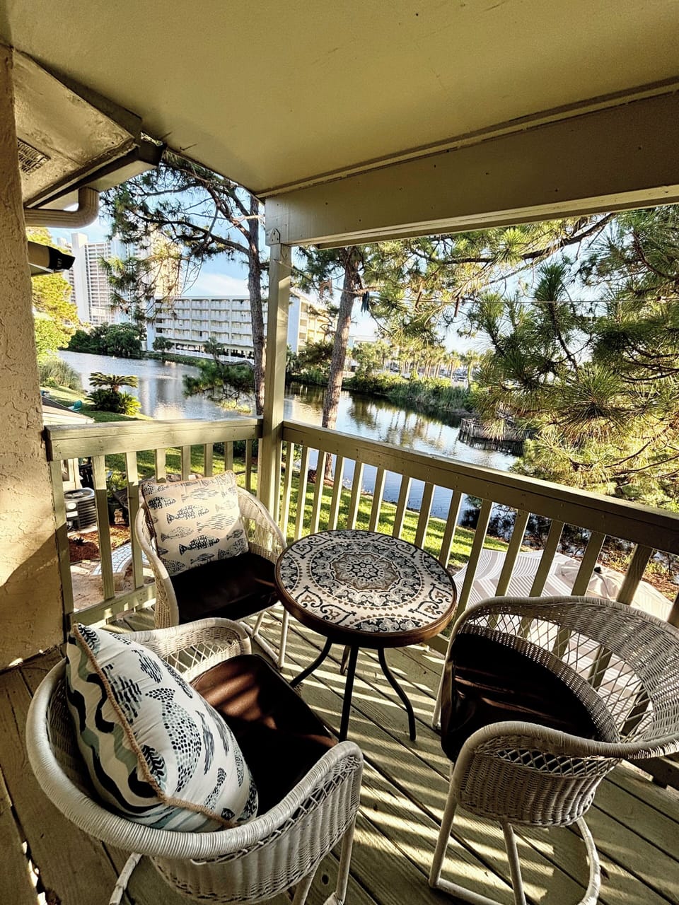 Relaxing view from our master balcony on a backyard, lake, and the Gulf.