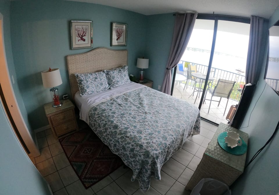 Master Bedroom with balcony access and 55" Smart TV.