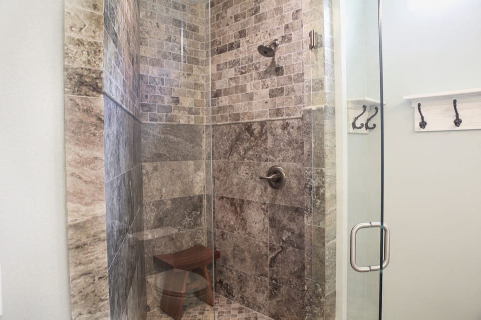 Travertine shower with teak bench