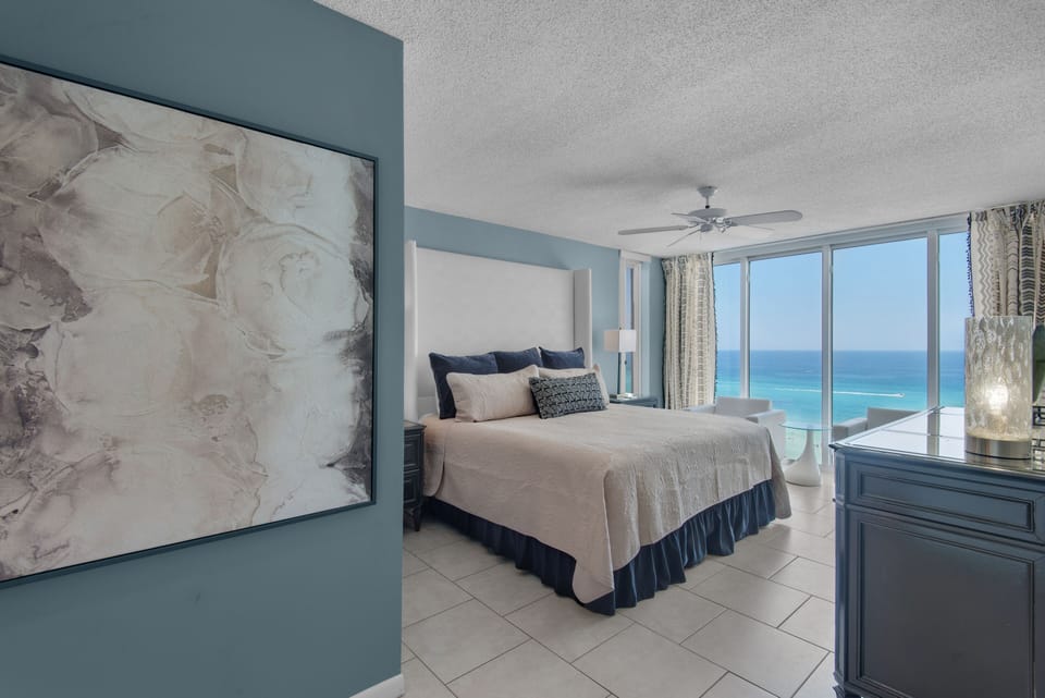 Master suite with balcony access, king bed, and adjacent full bath