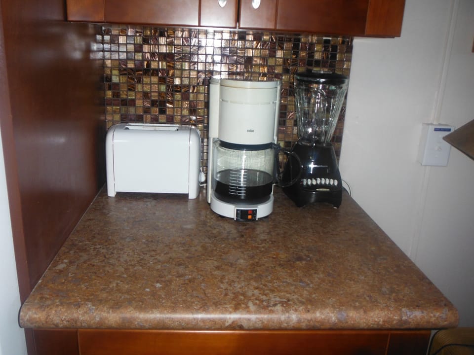 New cabinets with glass tile back splash, toaster, blender, and coffee maker
