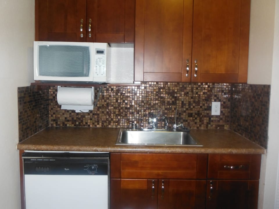 New cabinets with glass tile back splash behind the sink area
