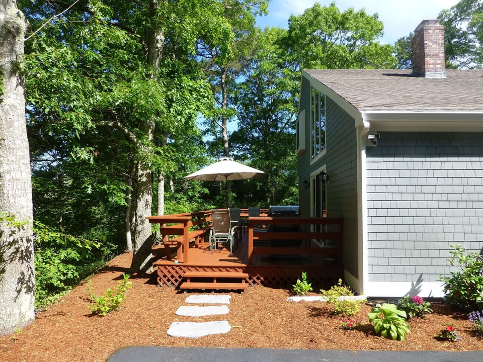 Wrap around deck off living and dining rooms with BBQ table and chairs.