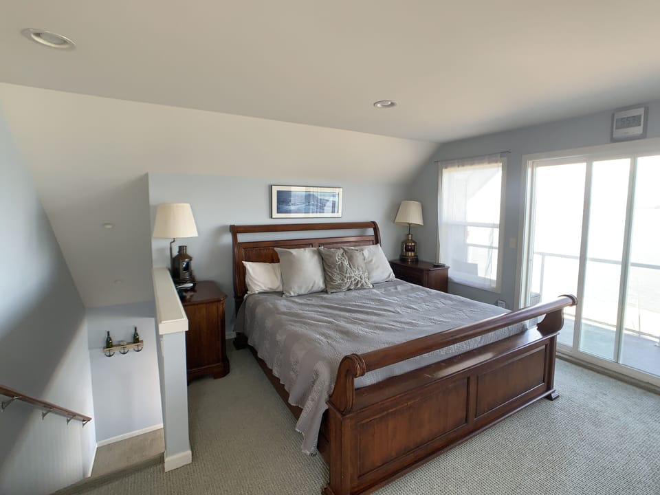 Upstairs master - king bed sleeps 2. Private balcony.