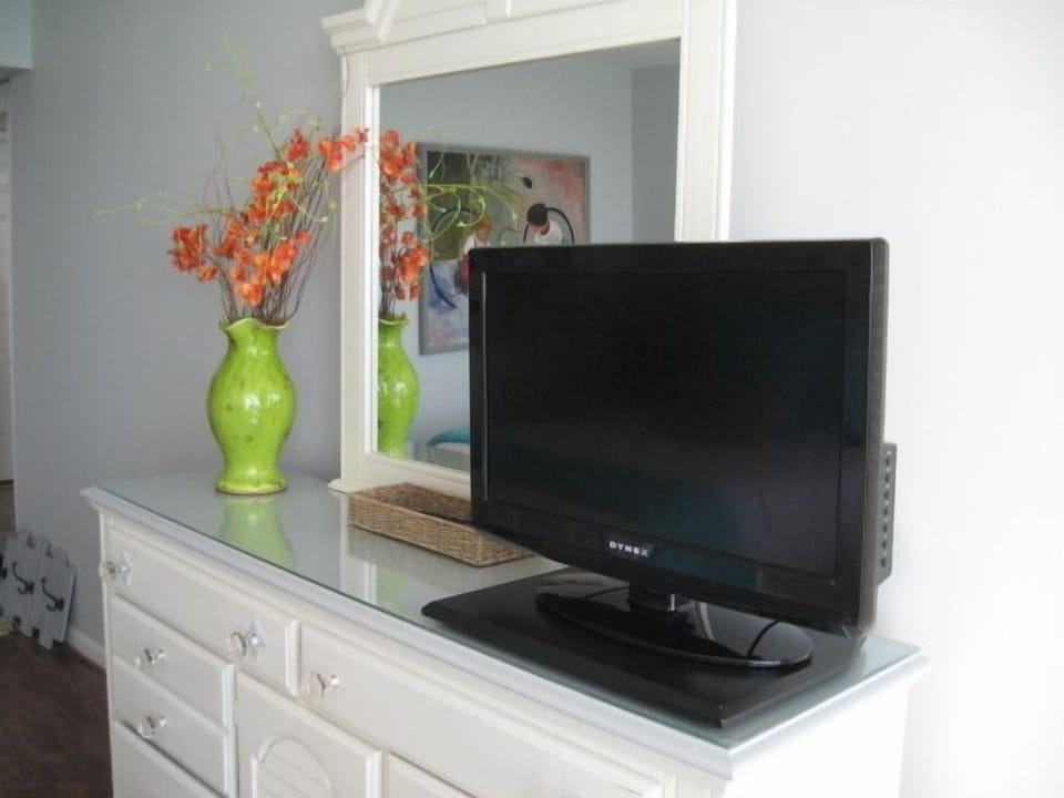 Guest room with flat screen TV & Dressers with glass tops