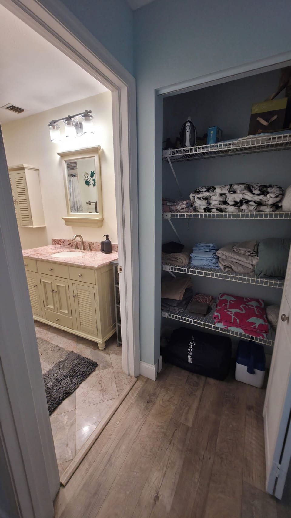 linen closet next to bathroom with extra towels, sheets, blankets , air mattress