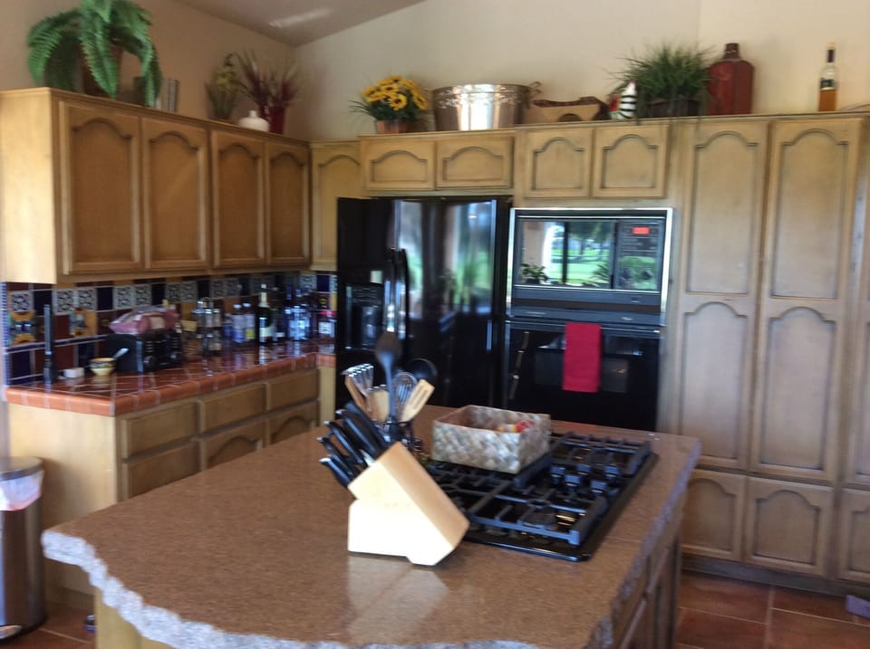 Kitchen with granite island and gas stovetop.