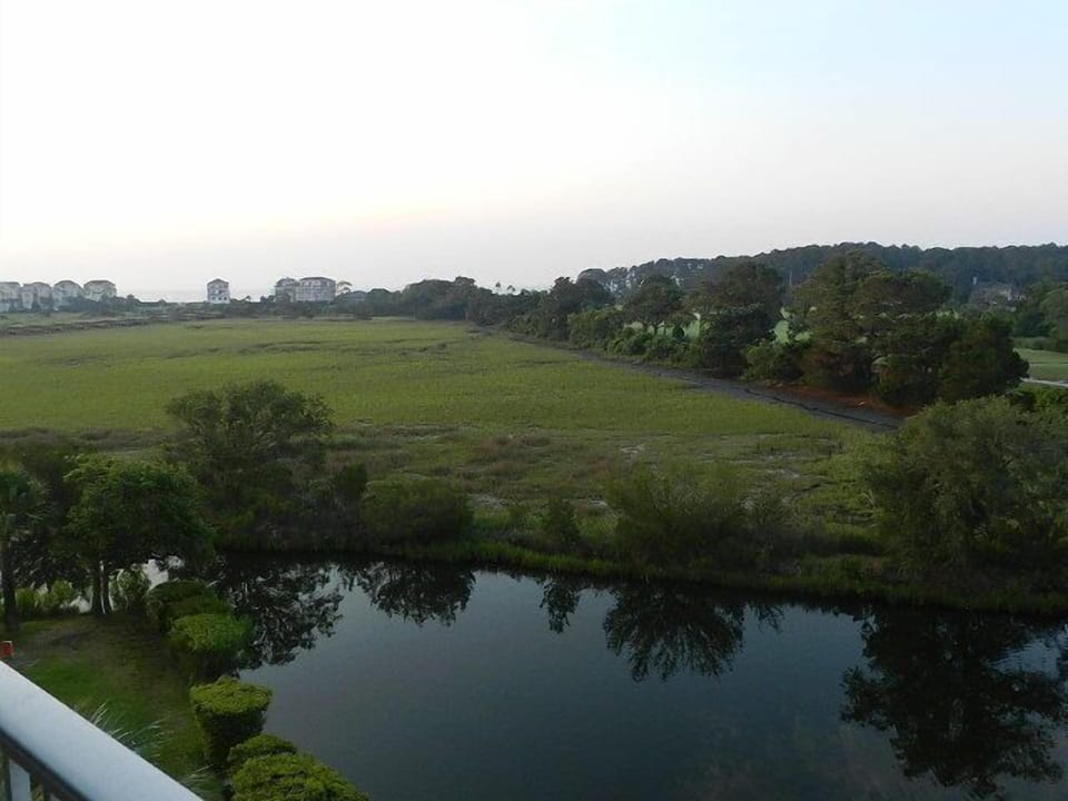 view from balcony sweeps from the golf course over the marsh to the ocean.

