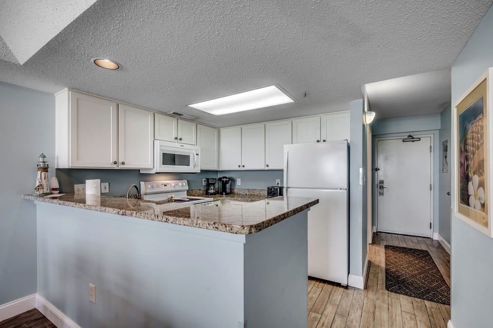 Updated kitchen with granite counter tops and shaker style white cabinets