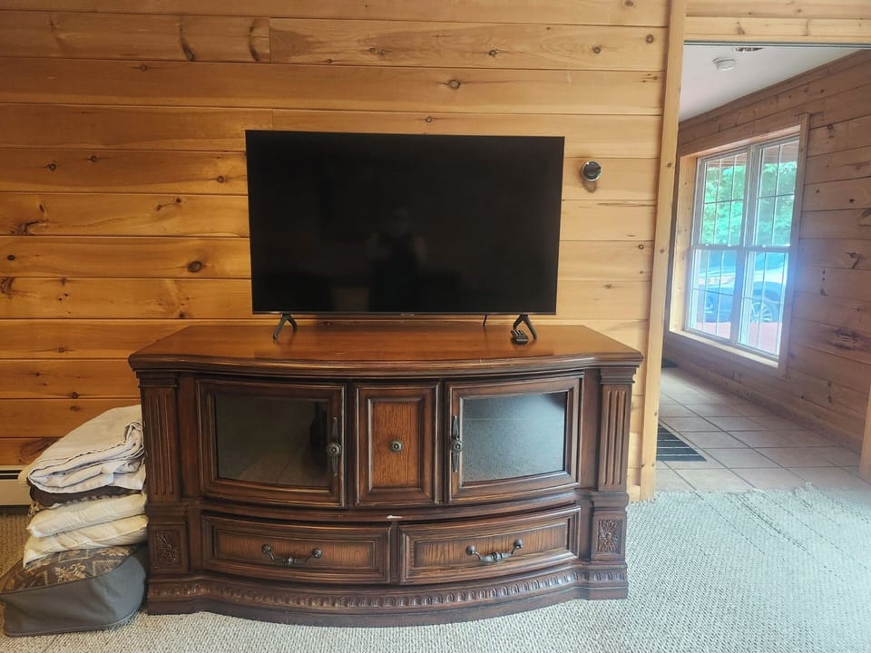 Smart TV in Downstairs room with view of entrance to house and doors to room