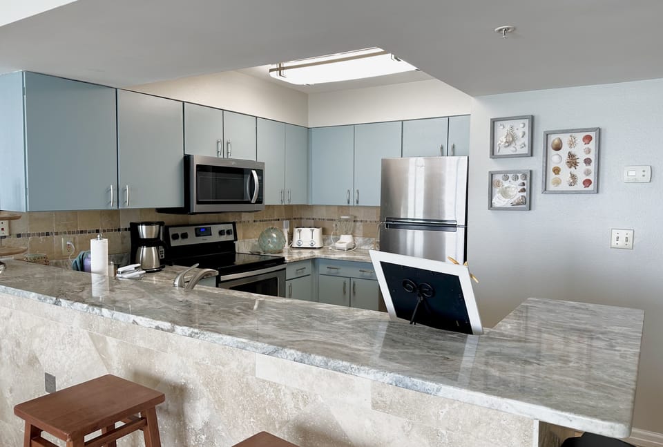 Well stoked kitchen, high top bar with 4 bar stools. Natural stone and marble 