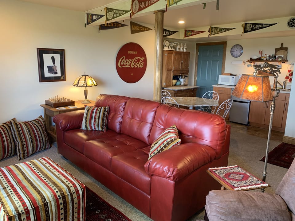 A red couch in the living room with a queen size pullout bed 