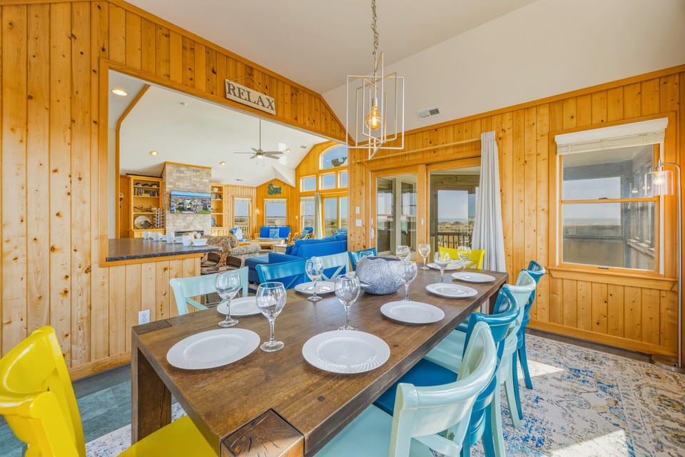 Your rustic dining room invites memorable meals with warm wood paneling and elegant table settings for eight.