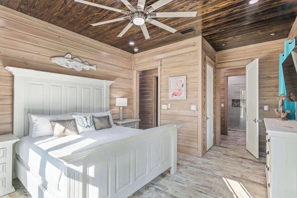 Minimalist bedroom w/ wood walls, high ceilings & restful design.