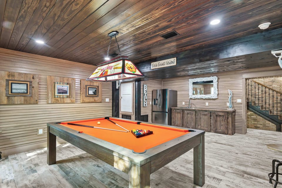 Game room w/ pool table & warm wood finishes for laid-back fun.