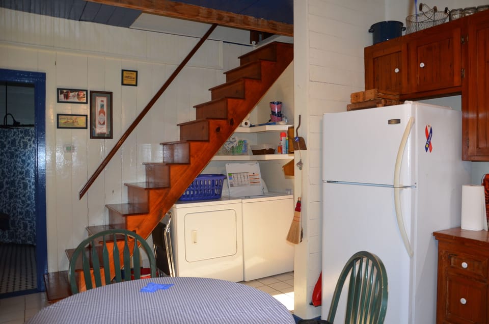 Kitchen- view of washer/dryer and stairs leading to upstairs bedroom loft.