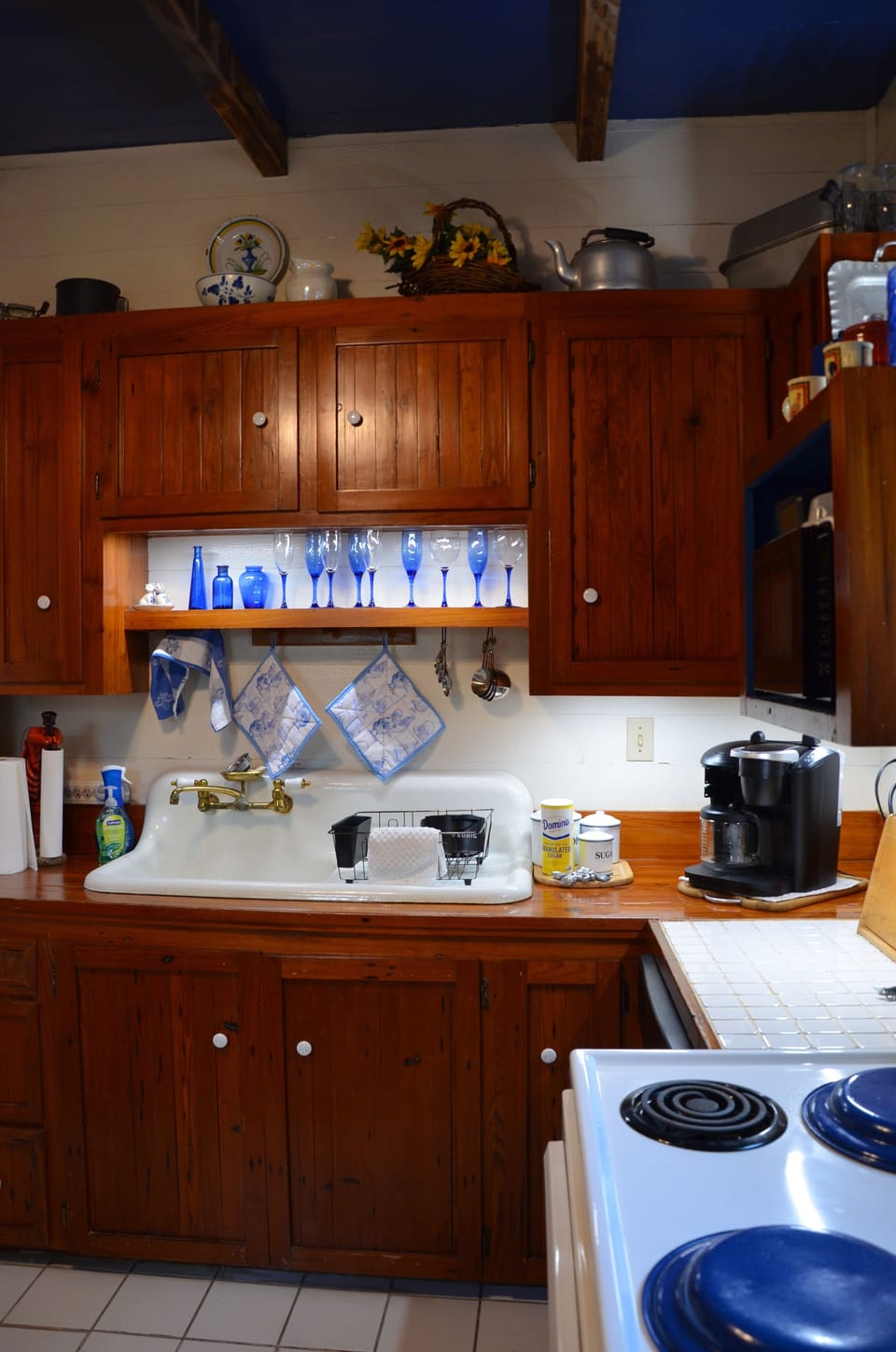 Kitchen view from in front of pantry- sink, counter space and electric stove.