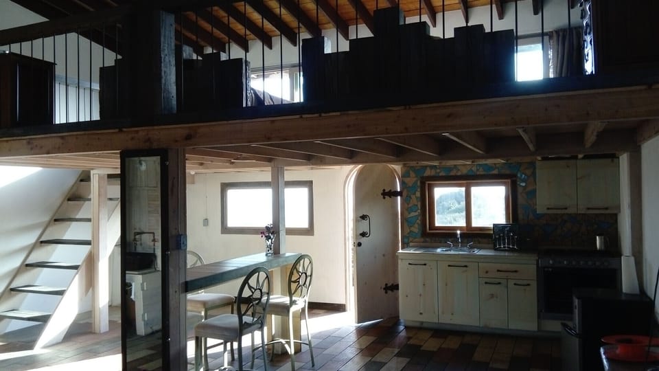 The loft has dining space and a kitchen down below and two queen beds upstairs