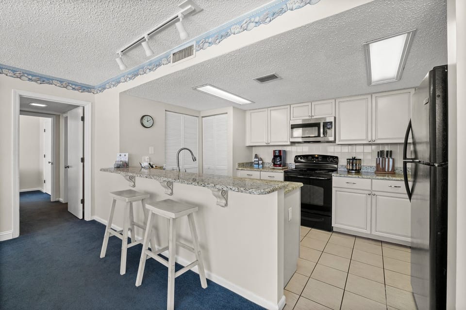 Fully equipped kitchen with two barstools. 