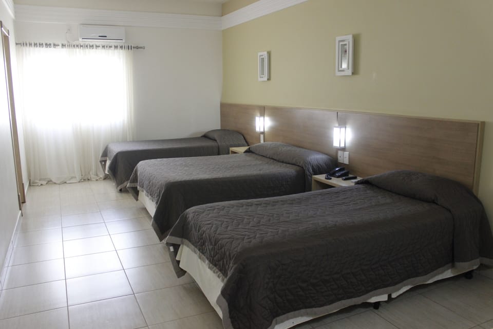 Deluxe Triple Room | Minibar, desk, laptop workspace, blackout drapes