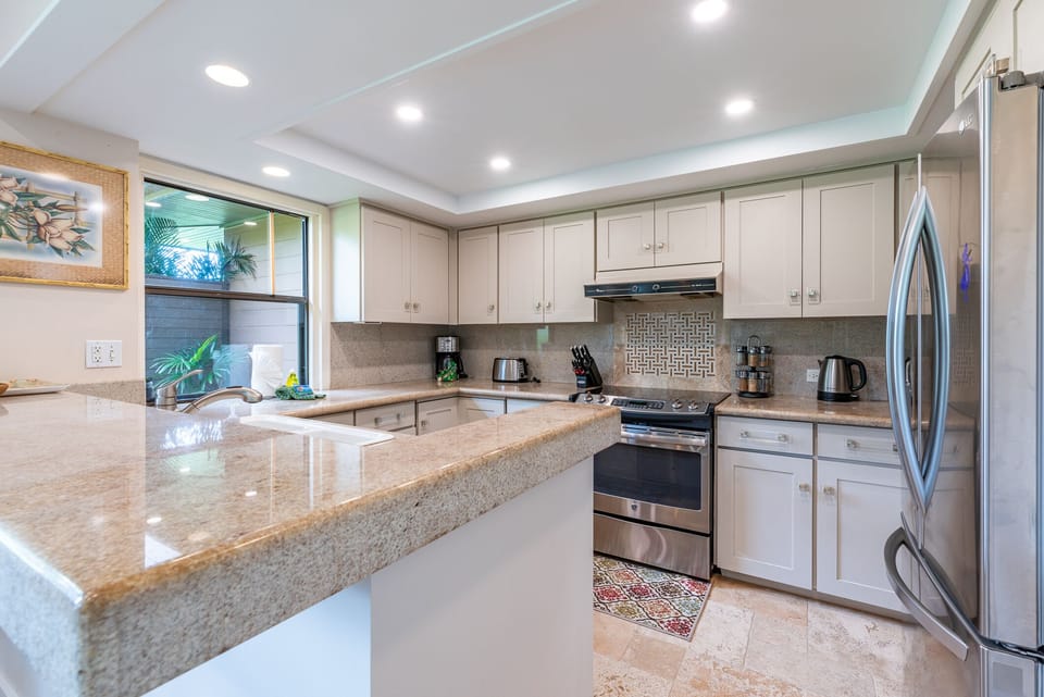 A spacious, fully equipped kitchen featuring stainless steel appliances, granite countertops for preparing delicious meals.