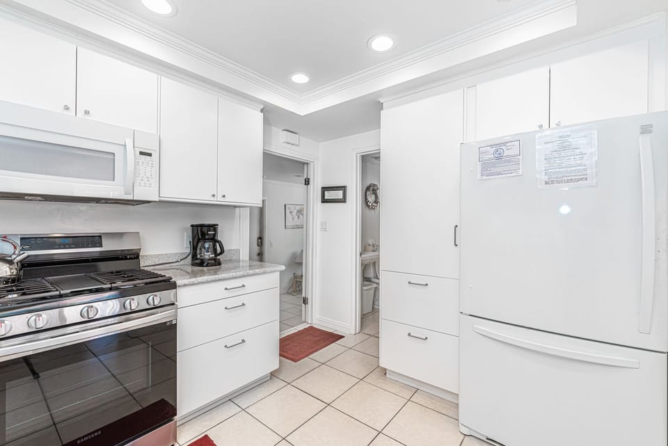 Bright, fully equipped kitchen with modern appliances and ample counter space for easy meal prep
                