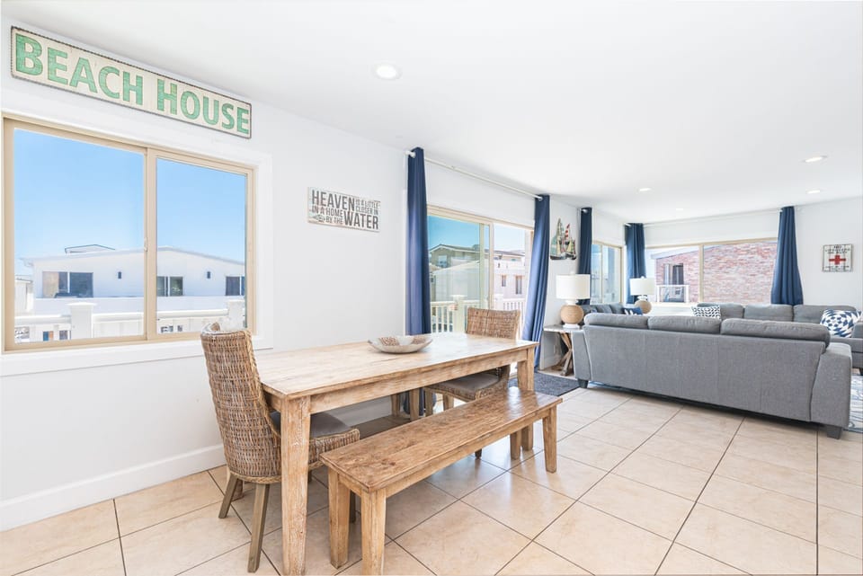 Open living and dining area with abundant natural light and a welcoming coastal atmosphere
                