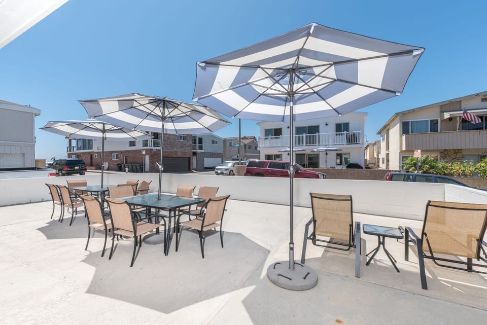 This home's oversized patio includes lounge chairs, two market umbrellas, and outdoor tables and chairs
                