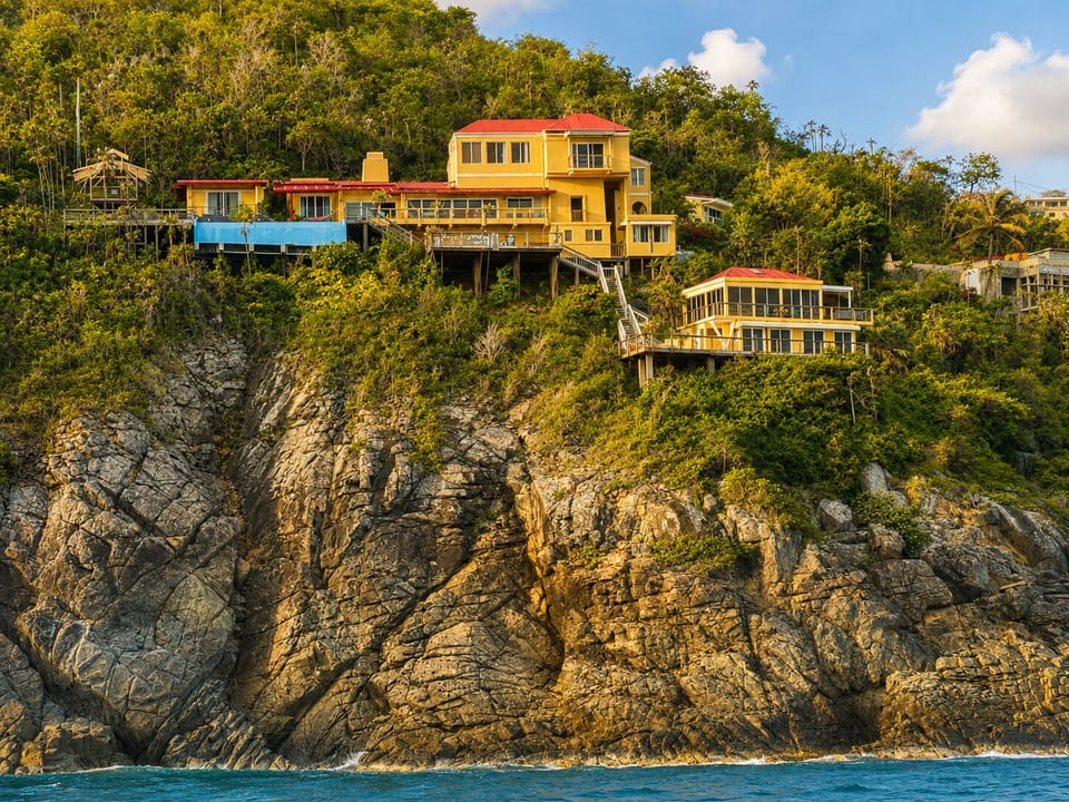 Spot this yellow retreat perched on the cliff, red roofs against green.