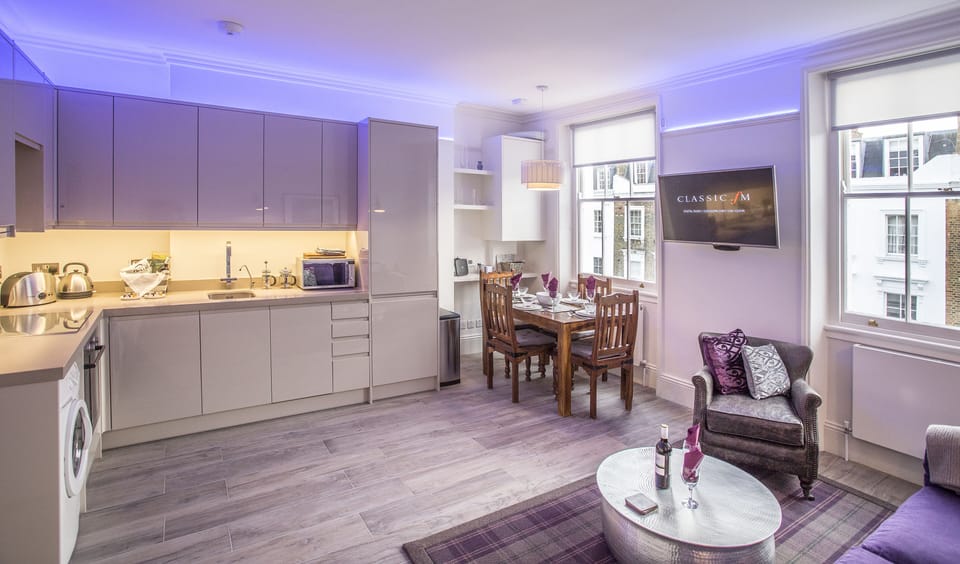 Open plan fully-fitted kitchen with dining table nearby