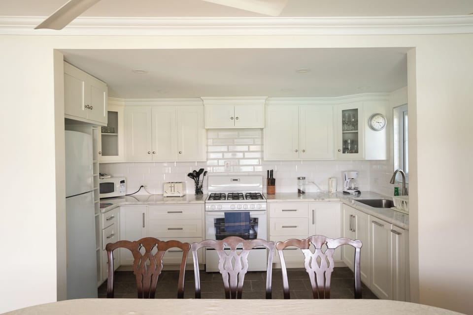 Bright and fully equipped modern kitchen featuring ample storage and cozy dining