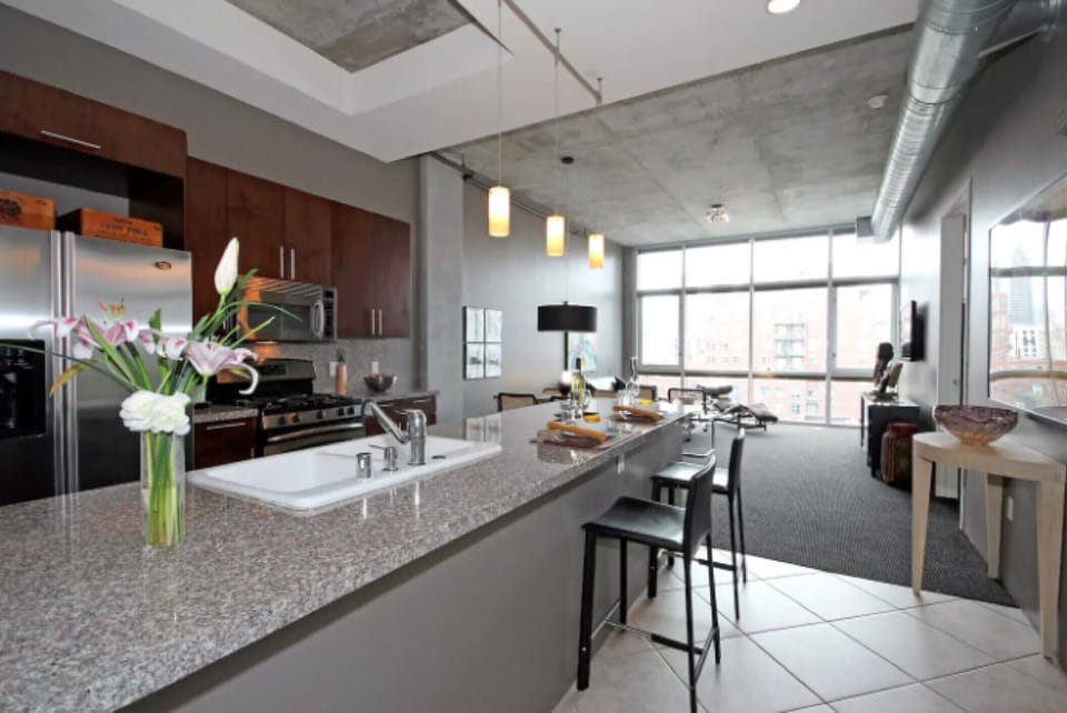 Warm, sunny living room with 12' ceilings and wall-mounted flat screen TV