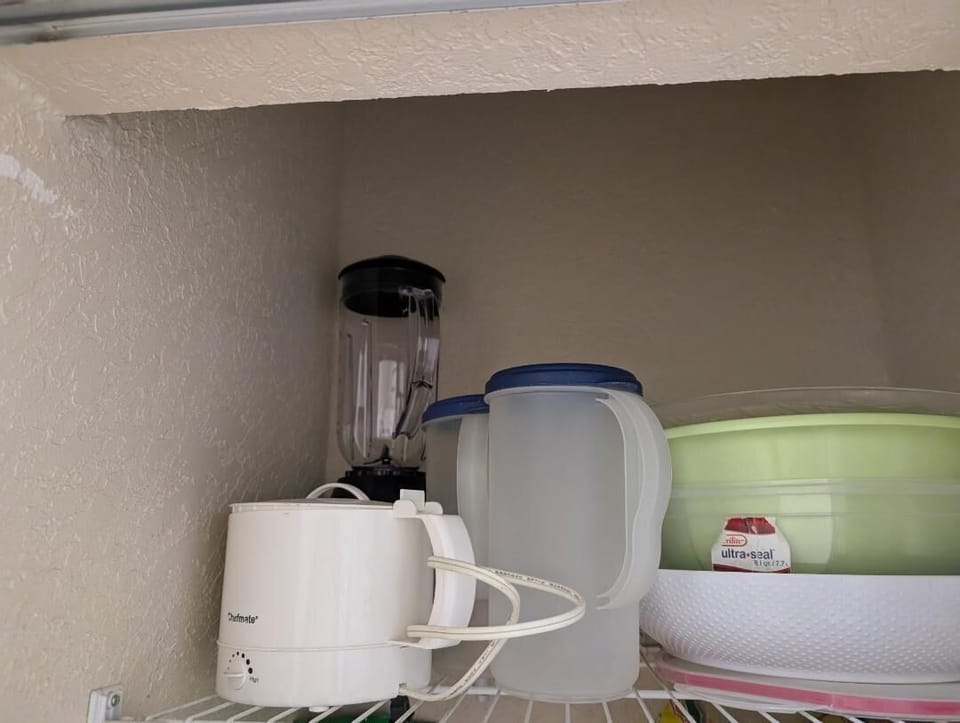 Kitchen closet with electric blender, electric kettle, large plastic bowls