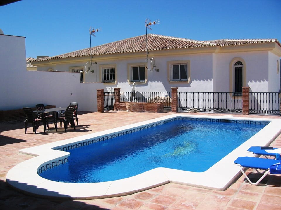 Private heated pool set in the back garden patio area