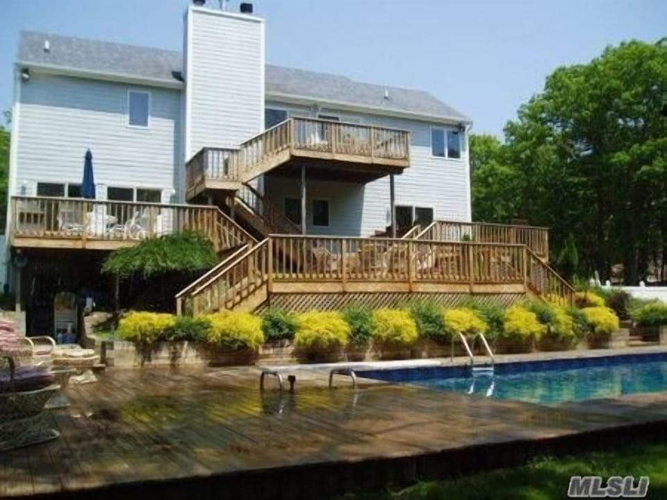 Back of house with pool and decks